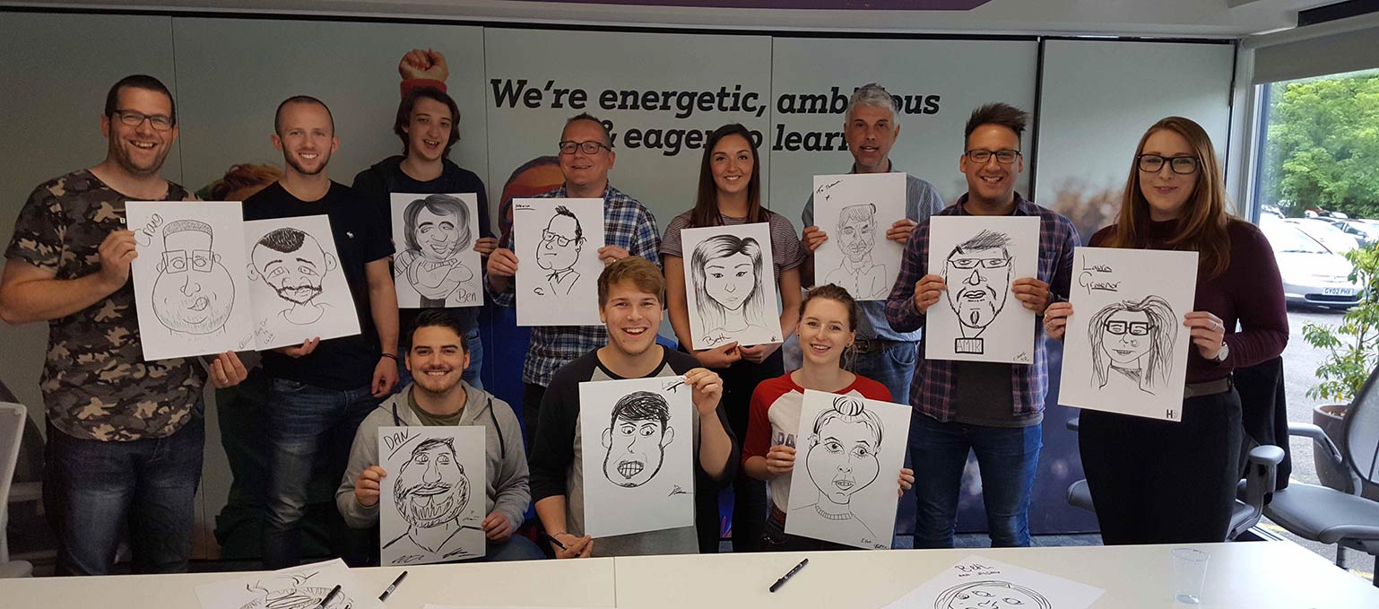 this photo shows the team drawing themselves after a Caricature Workshop from David Groves