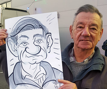 man with a big hooter holds his caricature up
