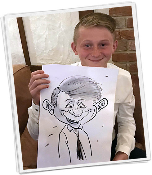 a cheeky boy holds his papered caricature